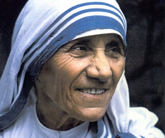Saint Mother Teresa smiling, wearing her white habit with a blue border